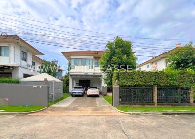 Exterior view of a residential building with driveway and cars