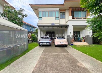 Two-story house with driveway and parked cars