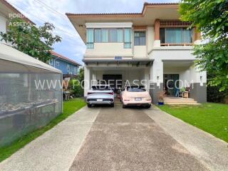 Two-story house with driveway and parked cars