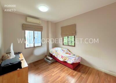 A cozy bedroom with wooden flooring and a small bed