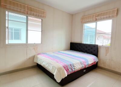 Simple empty bedroom with double bed and two windows