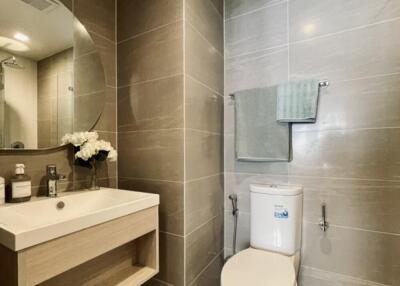 Modern bathroom with sink, wall-mounted mirror, and toilet