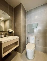 Modern bathroom with sink, wall-mounted mirror, and toilet