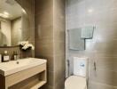 Modern bathroom with sink, wall-mounted mirror, and toilet