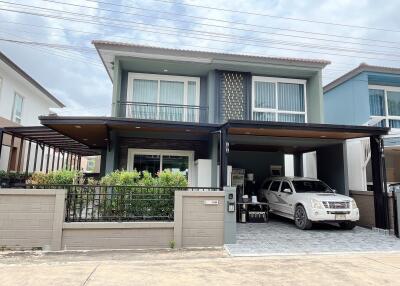 Two-story house with a carport and garden