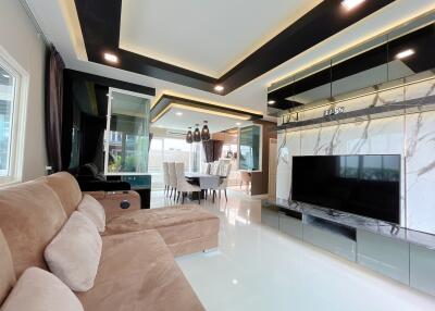 Spacious and modern living room with a large sofa and flat-screen TV