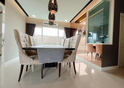 Modern dining area with glass table and plush chairs