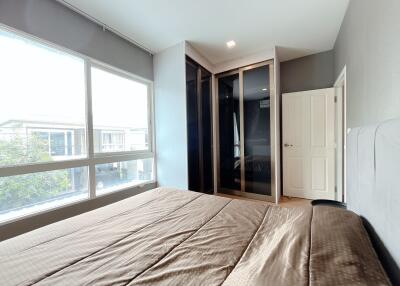 Modern bedroom with large window and built-in wardrobe