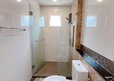 Modern bathroom with glass-enclosed shower and tile flooring