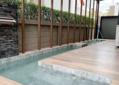 Modern pool area with wooden deck and glass roof