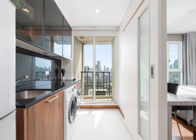 Modern kitchen with appliances and view of bedroom and balcony