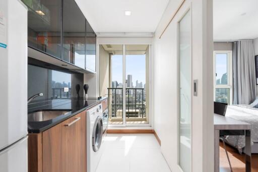 Modern kitchen with appliances and view of bedroom and balcony