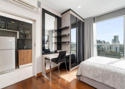 Spacious bedroom with a work desk and city view