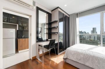 Spacious bedroom with a work desk and city view