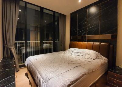 Modern bedroom at night with large window and luxurious furnishings