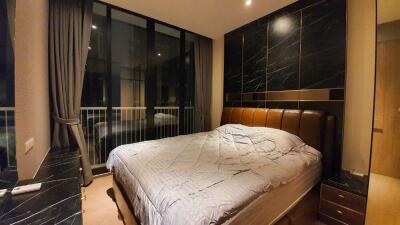 Modern bedroom at night with large window and luxurious furnishings