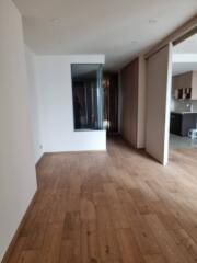 Living area with wooden flooring and partial kitchen view