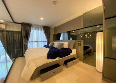 Modern bedroom with large bed, floor-to-ceiling windows, and stylish decor