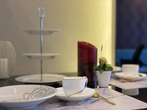 Dining table with cups, plates, and a candle