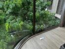 Living area with large curved glass windows and view of greenery