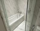 Modern white marble bathroom with bathtub and shower