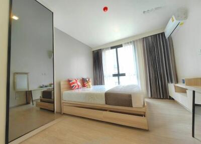 Bright modern bedroom with large bed, mirror wardrobe, and study desk