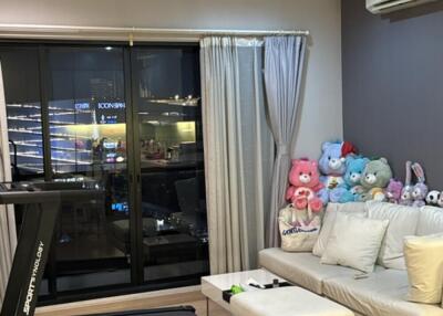 Modern living room with a sofa, table, treadmill, and stuffed toys