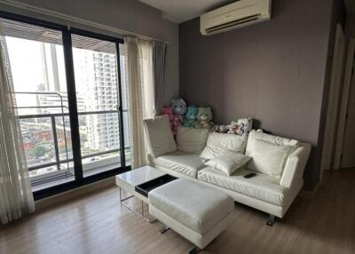 Living room with a couch, small coffee table, air conditioning, and a balcony view