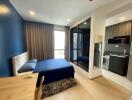 Well-lit modern bedroom with a workspace and a view into the kitchen