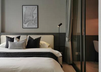 Modern bedroom with bed, pillows, bedside lamp, and wall art