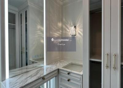 Well-lit dressing room with built-in storage and vanity mirror