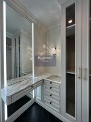 Well-lit dressing room with built-in storage and vanity mirror