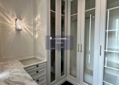 Luxurious walk-in closet with marble countertop and built-in wardrobes