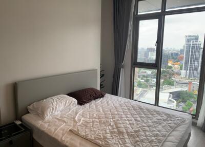 Bedroom with a large window and city view