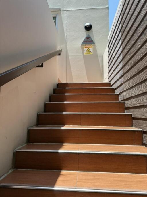 Outdoor staircase with brown steps leading to a door