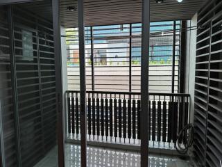 A modern balcony with glass doors and metal railings.