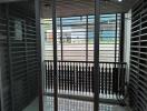 A modern balcony with glass doors and metal railings.