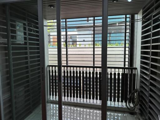 A modern balcony with glass doors and metal railings.