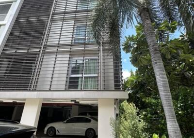 Exterior view of modern building with parking area and surrounding greenery