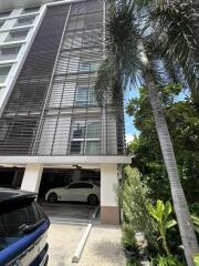 Exterior view of modern building with parking area and surrounding greenery