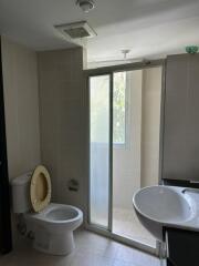 Bathroom with toilet, sink, and large window