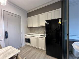 modern kitchen with white cabinetry and black refrigerator