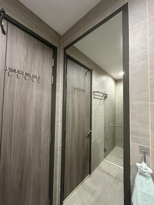 Modern bathroom with shower area and hooks on the door