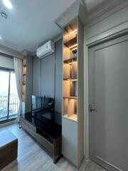 Modern living room with built-in shelving, air conditioning, and large window