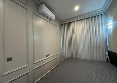 Spacious bedroom with large windows and wall-mounted air conditioner