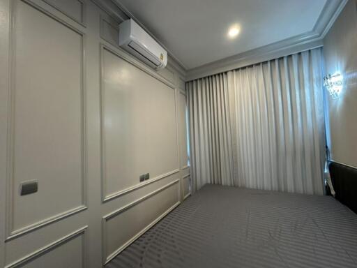 Spacious bedroom with large windows and wall-mounted air conditioner