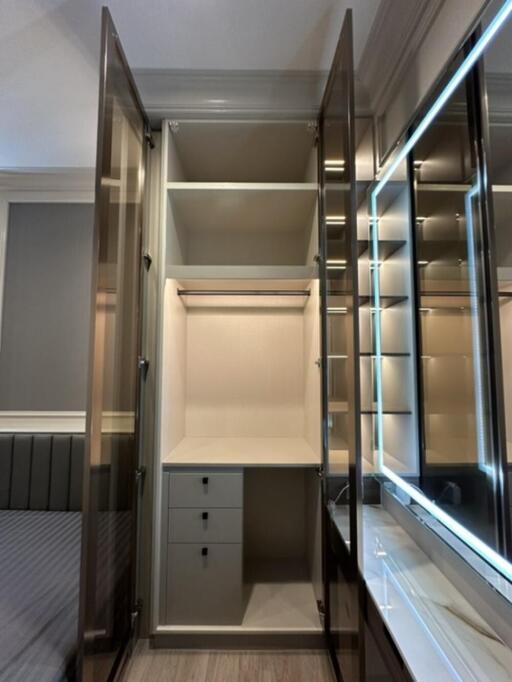 Bedroom with open closet and illuminated vanity mirror