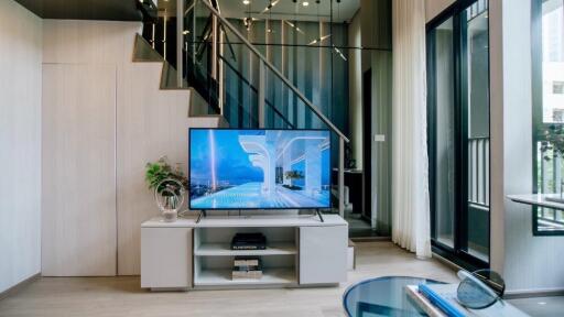 Modern living room with a staircase and television