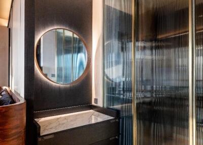 Modern bathroom with round mirror and glass partition