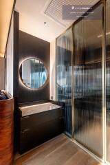 Modern bathroom with round mirror and glass partition